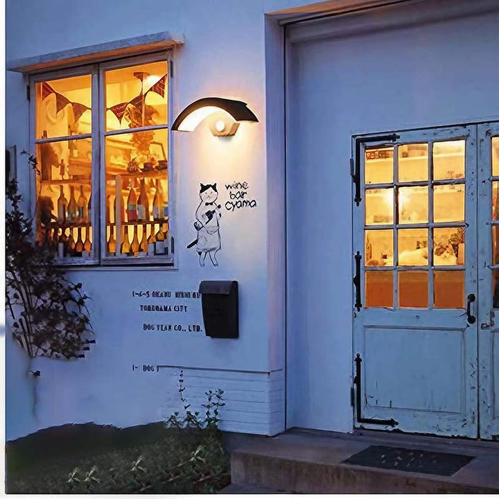 Wine bar exterior with illuminated interior, decorative wall art, and door.