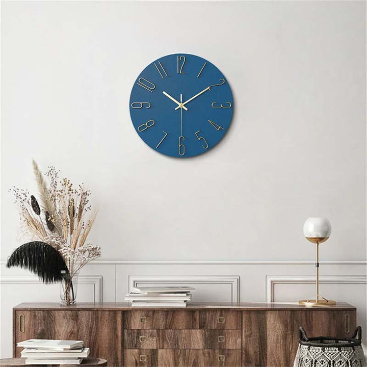 Blue wall clock on a white wall above a wooden console table.