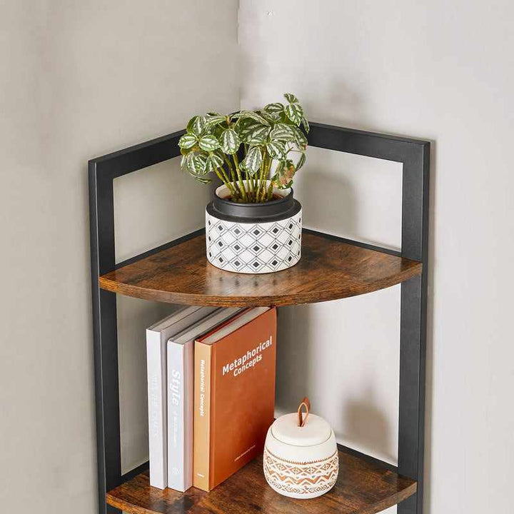Close-up of upper tiers of rustic corner bookcase with decorative plant pot, books, and ceramic jar