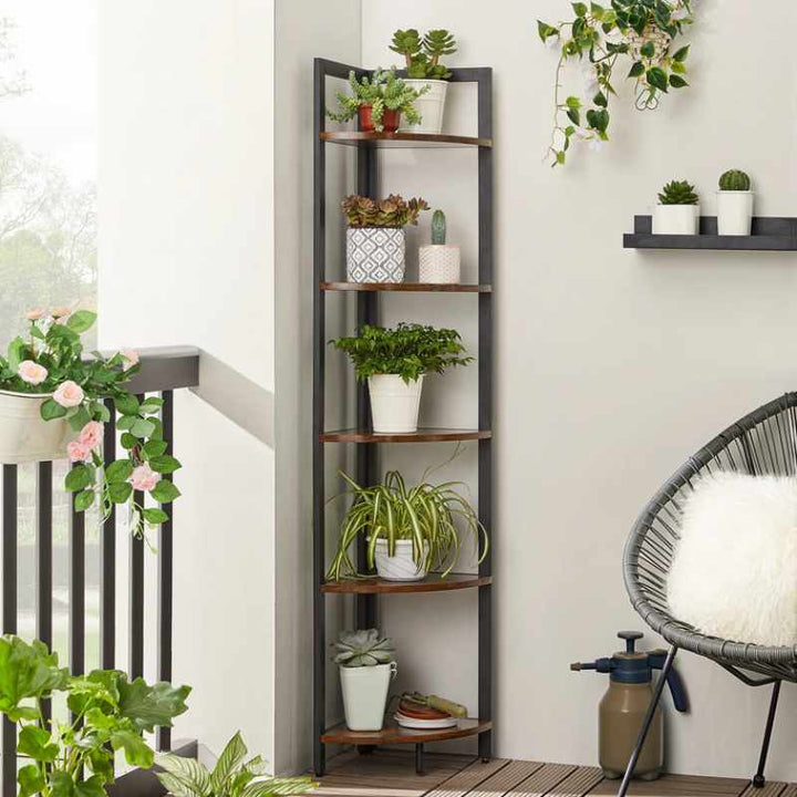 HYLLA 5-tier rustic corner bookcase styled as indoor plant rack with multiple potted plants in modern balcony setting