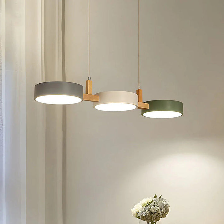 Stylish dining room pendant light with three Nordic cylinder shades in grey, white, and green.