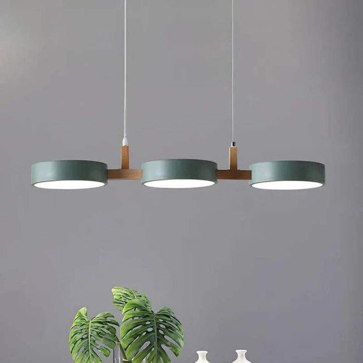 ALVA Nordic cylinder pendant light in green, white, and grey for a modern kitchen setting.