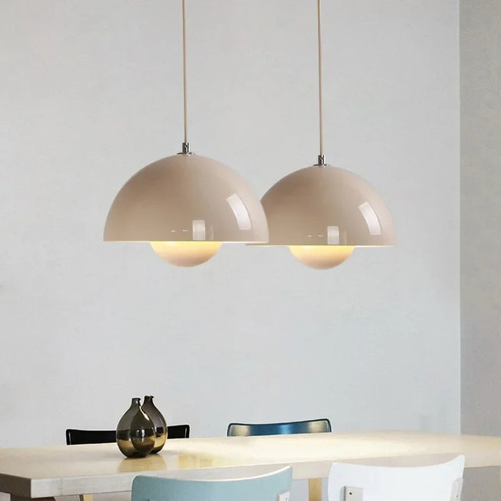 Beige pendant lights hanging above a dining table with a neutral background