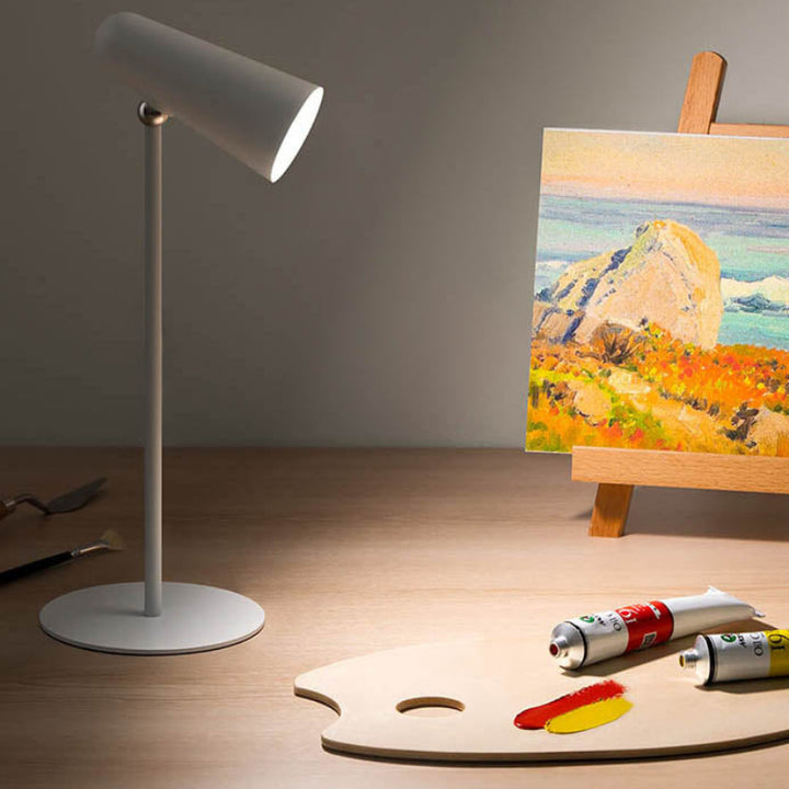 Cordless white LED lamp on art desk, ideal for precision lighting during painting or craftwork.