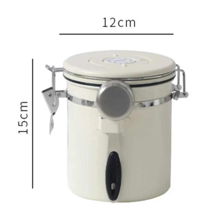Cream airtight coffee canister with silicone seal and stainless steel scoop, 12 cm × 15 cm.