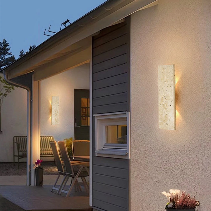 Modern natural stone LED wall sconces on white exterior wall, warm outdoor lighting