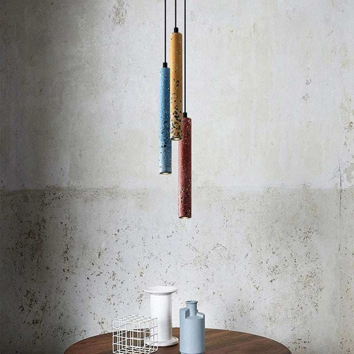 Cluster of BETON modern cement pendant lights in yellow, blue, and red