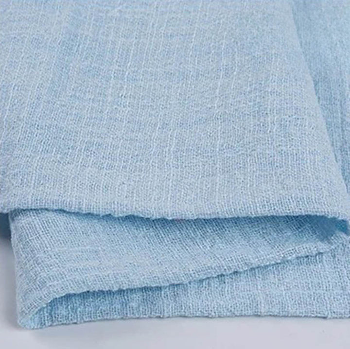 Folded baby blue cotton napkin for Weddings and Elegant uk Dining Decor on the white table.