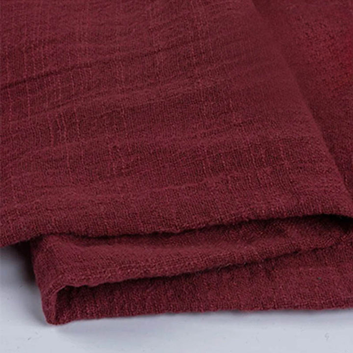Folded burgundy cotton napkin for Weddings and Elegant uk Dining Decor on the white table.