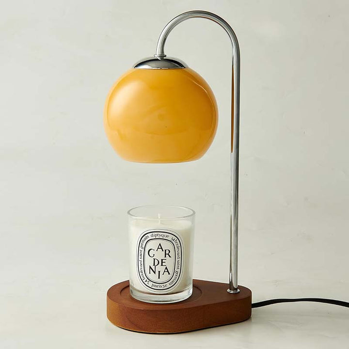 Candle warmer with a yellow shade and wooden base featuring a candle 