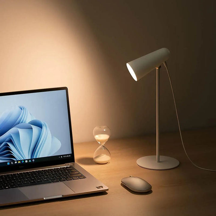 Touch LED desk lamp illuminating a laptop setup, great for home office or remote working.