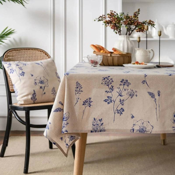 Beige tablecloth with blue floral pattern on a dining table in a bright room.