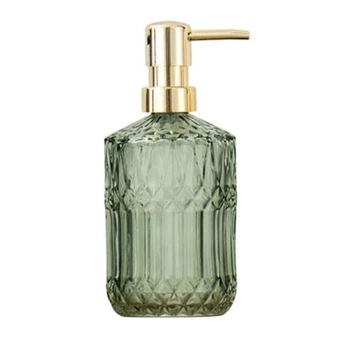 Green glass soap dispenser with gold pump on a white background