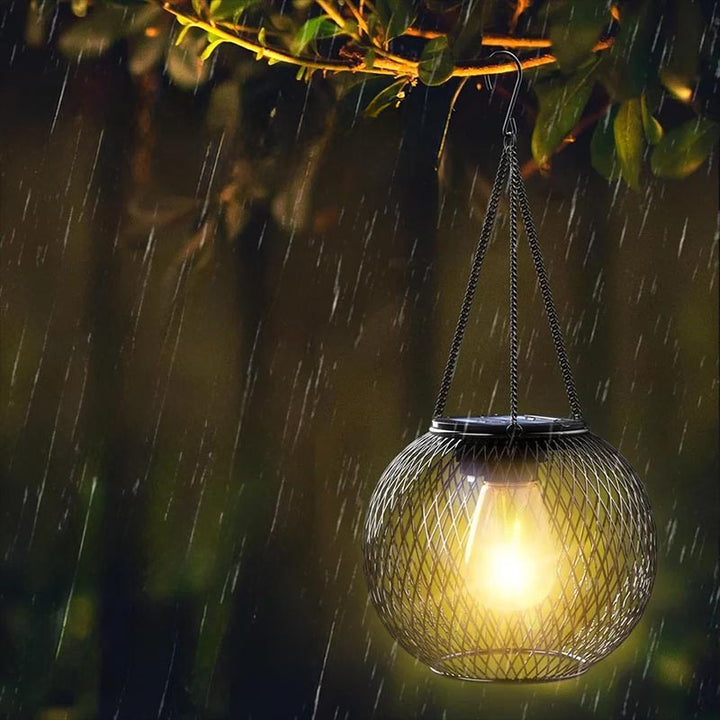 Waterproof decorative solar lantern hanging in rain, ideal for garden, patio, or balcony lighting.