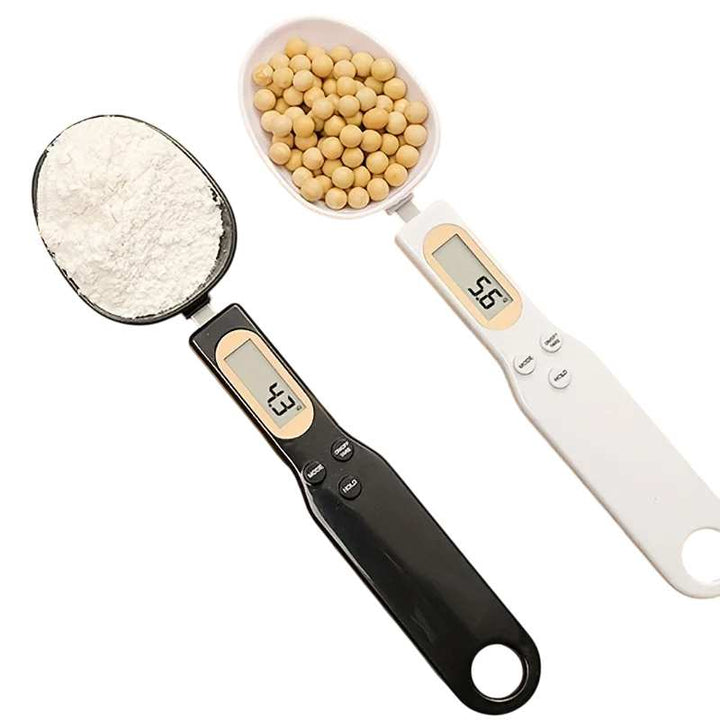Digital kitchen scale with measuring cups filled with flour and beans on a white background