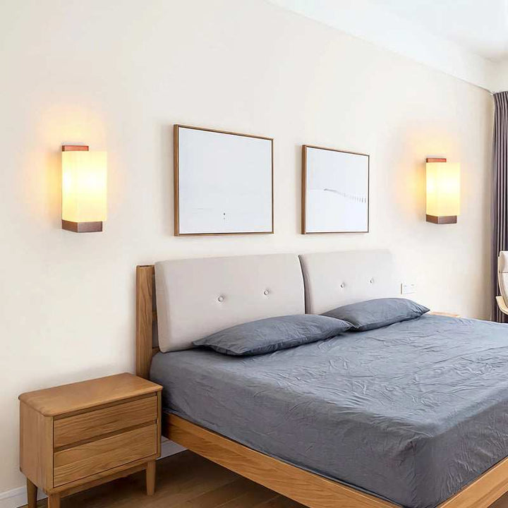 Pair of Nordic wood wall lights installed beside bed, soft warm illumination for cozy ambience.
