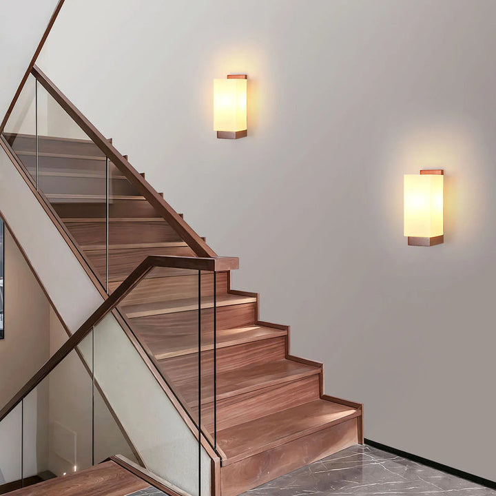 Two Nordic wooden wall sconces illuminating staircase with warm ambient lighting.
