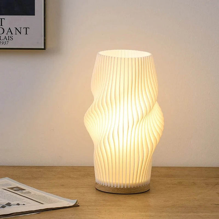MOLLEN wavy 3D printed lamp on a desk, providing soft ambient light for reading or late-night workspaces.