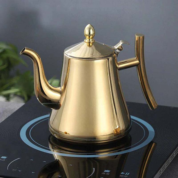Gold Electric teapot on a black stovetop with a blurred background