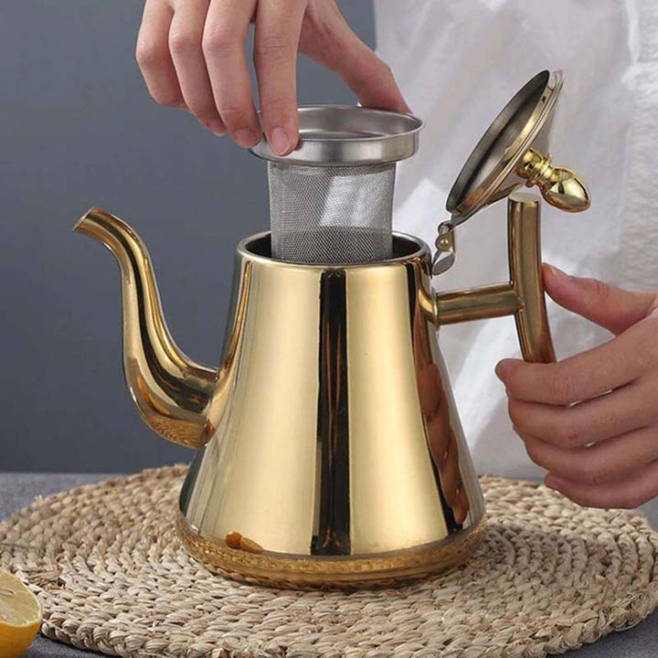Gold Electric teapot with a person adjusting a metal filter on a woven mat.