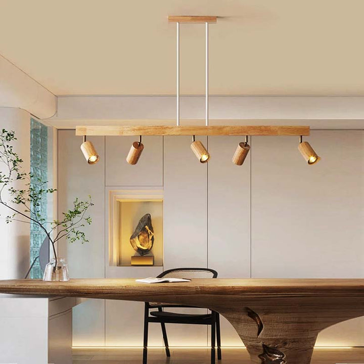 Modern dining room with a long wooden table and pendant lights.