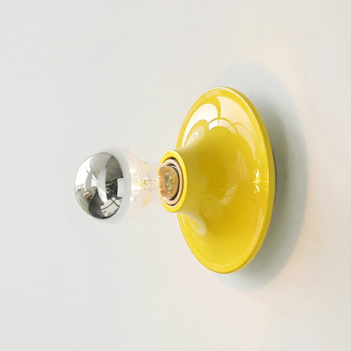 FYR LED wall lamp in vibrant yellow metal with exposed round bulb Nordic style lighting