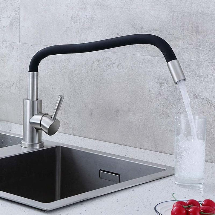 Modern Kitchen tap with a glass of water being filled, set against a concrete wall.