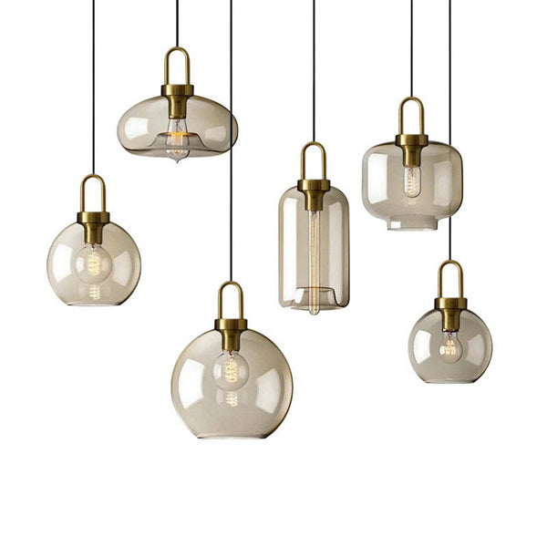 Collection of industrial glass pendant lights in 7 vintage bulb shapes with brass fittings, perfect for ceiling lighting.