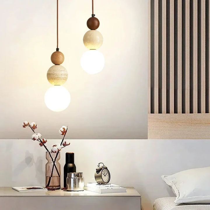 Cream pendant lamp with stone and wood accents hanging above a modern side table