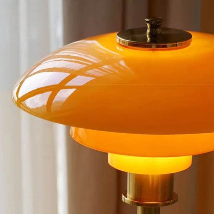 Minimalist Orange Table Lamp with gold accents on a blurred background