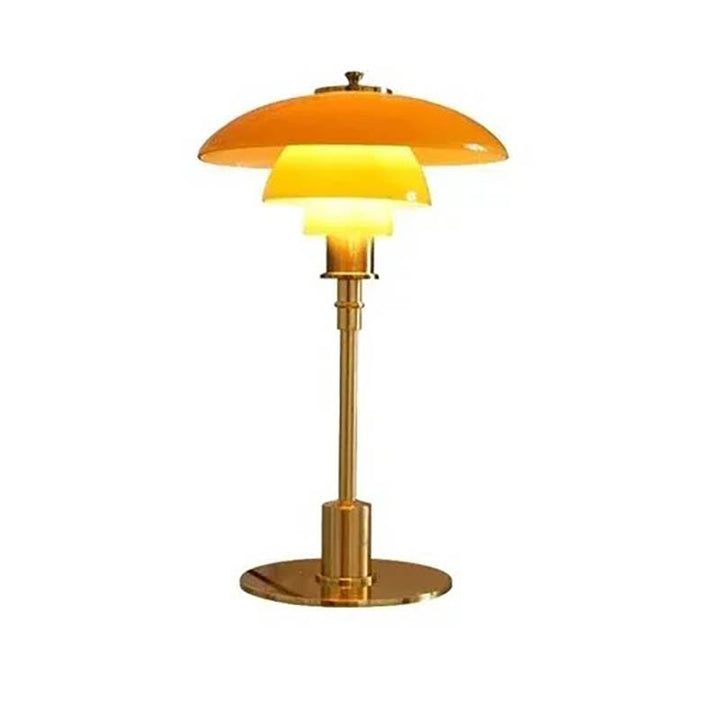 A minimalist glass table lamp with a brushed brass frame, featuring a three-shade system and a round base.