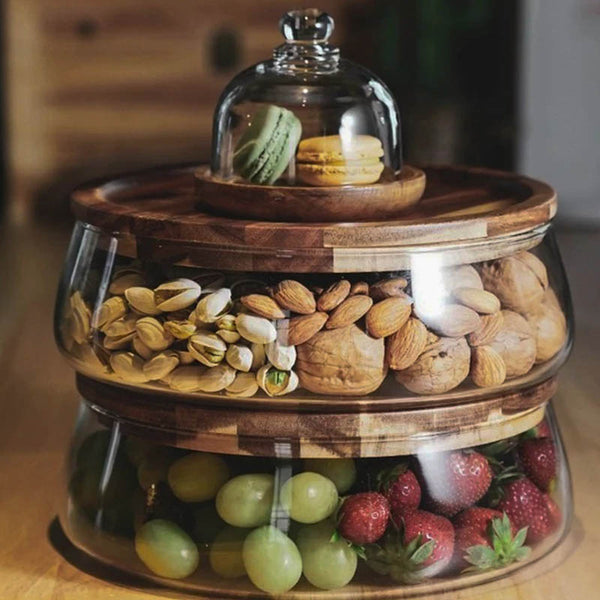 Stacked glass food storage jars with acacia wood lids, filled with mixed nuts and fruits for stylish Scandinavian kitchen storage.
