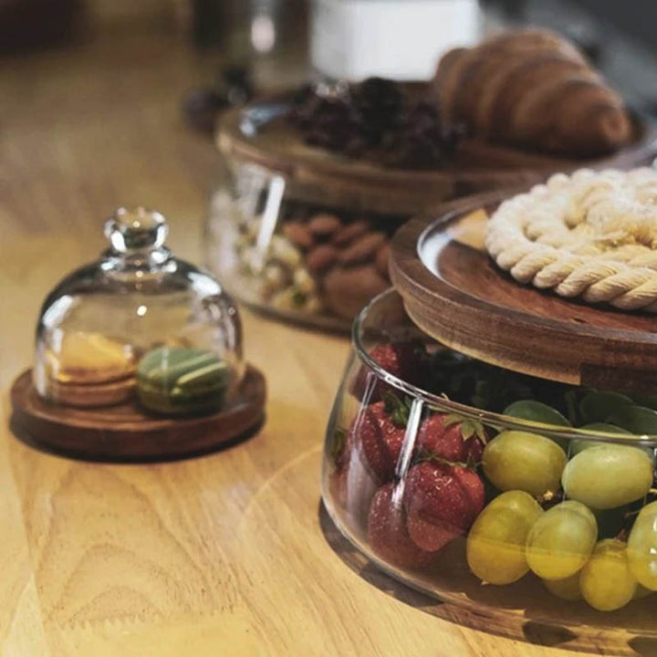 Small glass jar with dome lid and wooden base, filled with colourful macarons for elegant kitchen display.