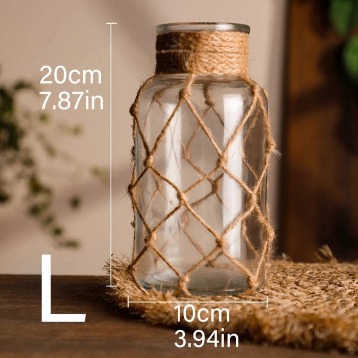Glass vase with jute rope netting, placed on a surface with dimensions indicated.
