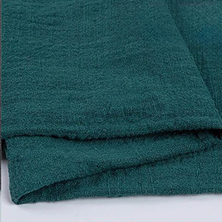 Folded green cotton napkin for Weddings and Elegant uk Dining Decor on the white table.