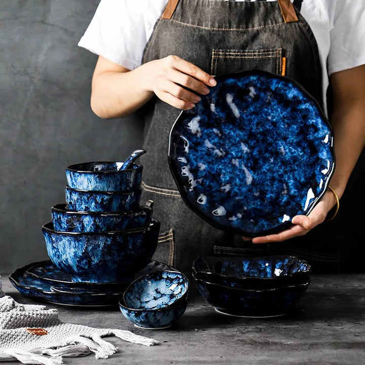 Handcrafted blue ceramic dinnerware set with glossy glaze, featuring plates and bowls in Nordic Japandi style