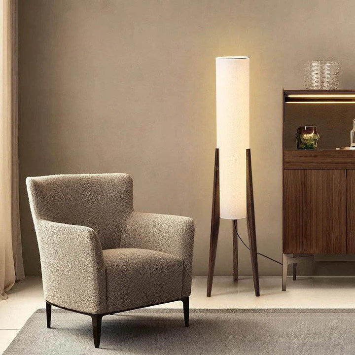 Tall Japanese-style wooden floor lamp casting soft glow in a minimalist living room corner.