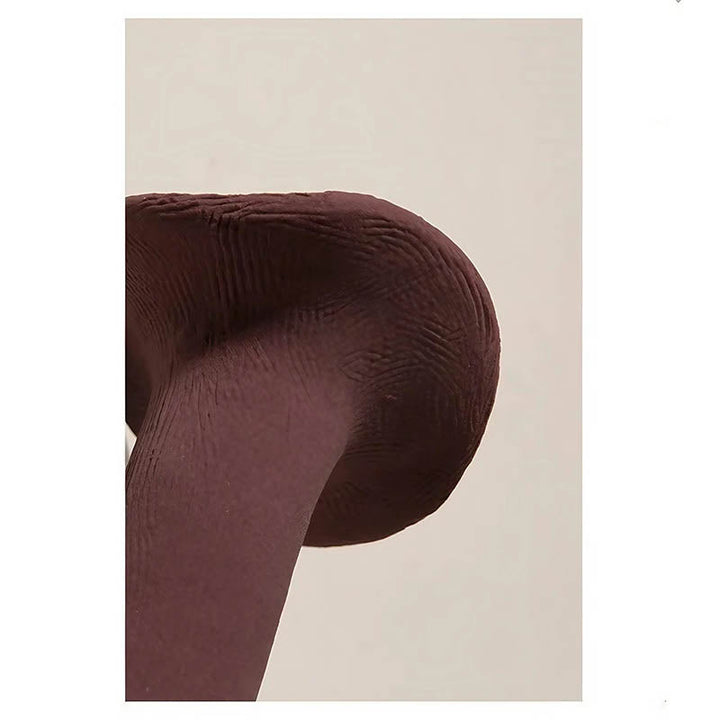 Close-up of curved ceramic vase spout in matte aubergine finish highlighting sculptural craftsmanship and organic form