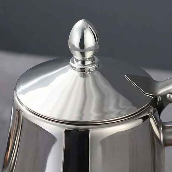 Close-up of a silver Silver stainless steel induction kettle lid with a dark background
