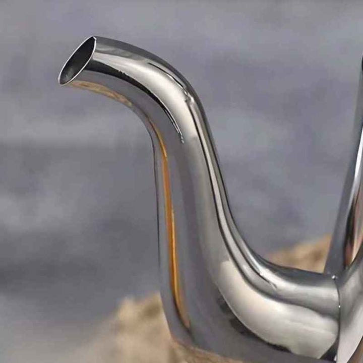 Close-up of a shiny metal exhaust pipe against a blurred background