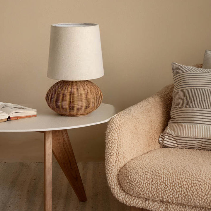 Small LUN rattan round table lamp on white table, warm Nordic lighting in Scandi-style uk bedroom interior