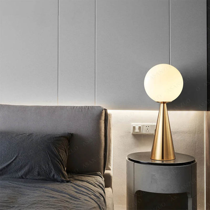 Frosted glass ball table lamp on black bedside table, warm bedroom lighting with a Nordic touch.