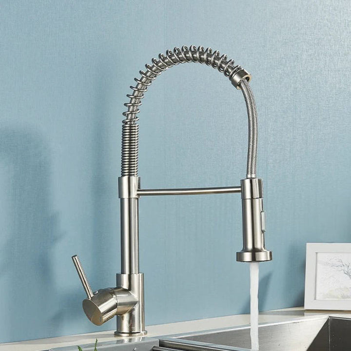 Stainless steel kitchen tap with a blue wall background