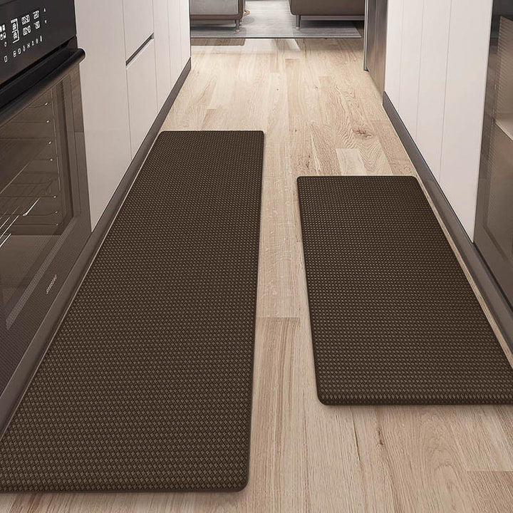 Two brown kitchen mats on a wooden floor in a kitchen setting.