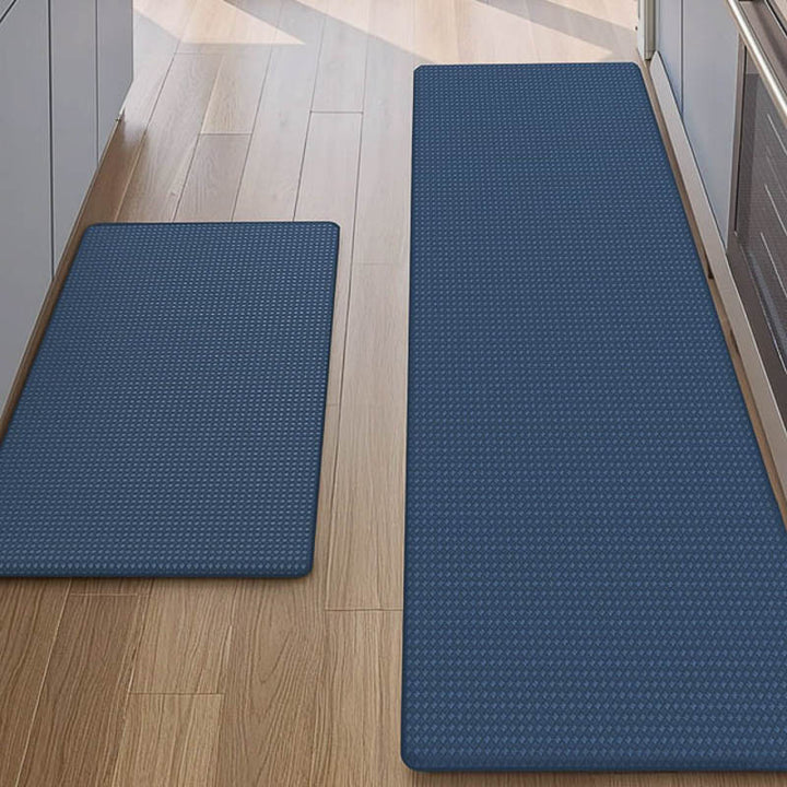 Two blue textured kitchen mats on a wooden floor.