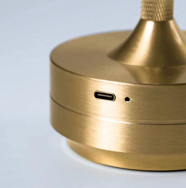 Detail view of gold LANTERNE cordless table lamp, USB-C charging port and sleek metal finish