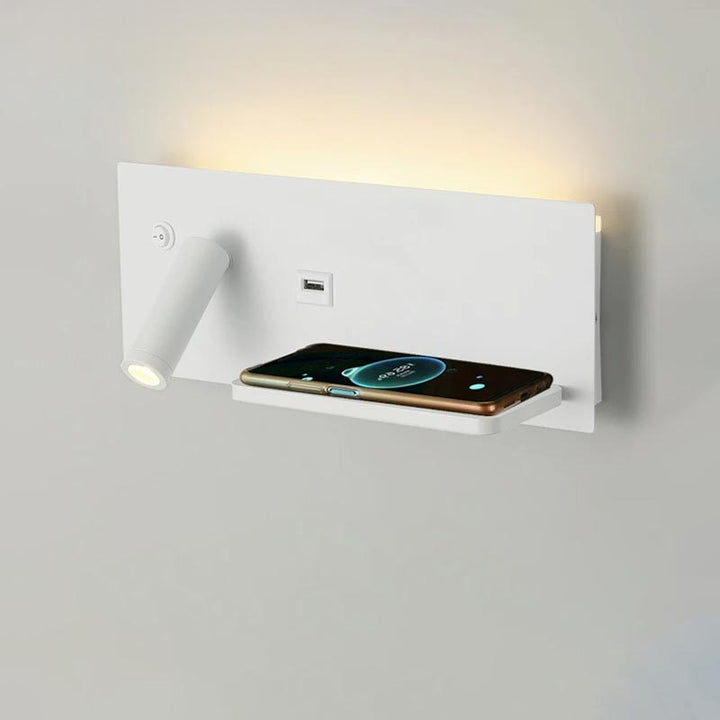White wall-mounted device with a shelf holding a smartphone on a light gray background
