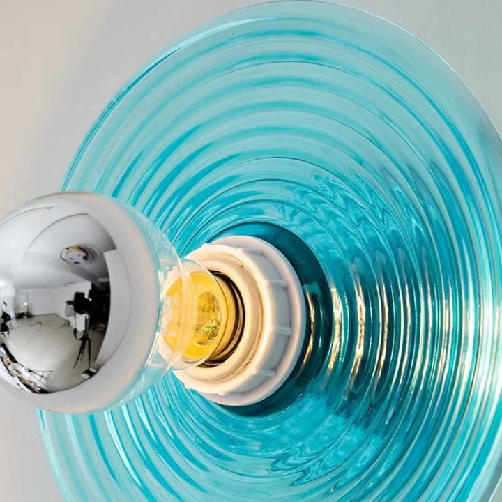 Close-up of a light bulb with a blue glass shade on a white background