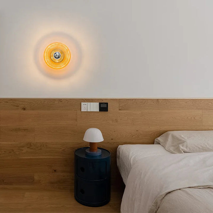 Modern bedroom with a wall sconce lightning fixture and bedside table.