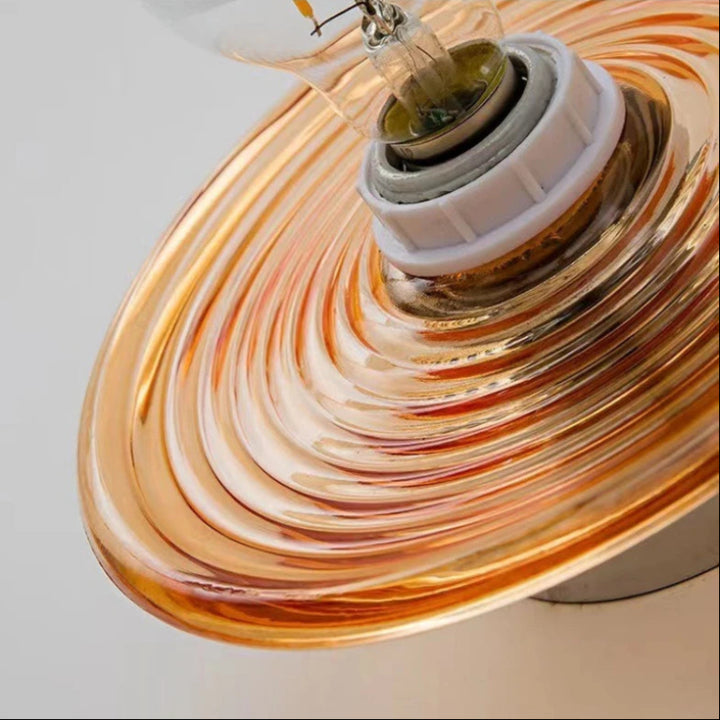 Close-up of a glass lampshade with concentric circular patterns on a white background
